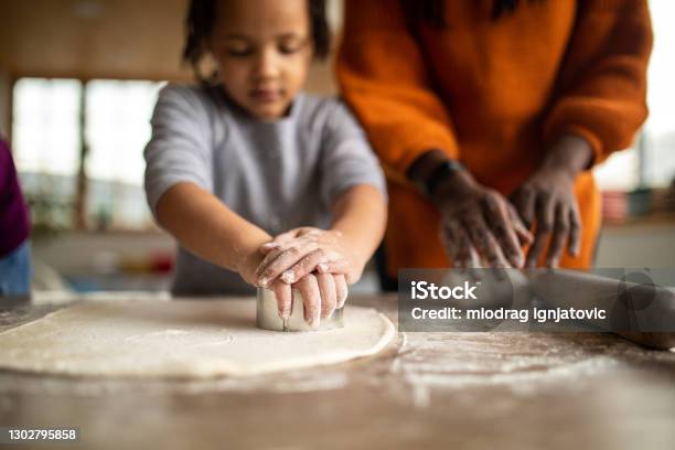 Sisters Helping Mother To Prepare Dough In Kitchen At Home Stock Photo - Download Image Now