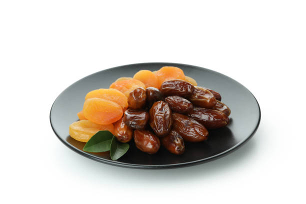 istock Plate with dried dates and apricots isolated on white background 1302796956