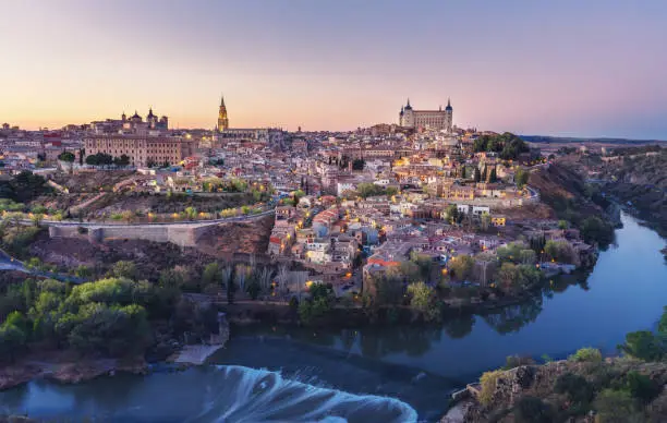Beautiful view of Toledo city skyline with Cathedral, Alcazar and Tagus River at sunset - Toledo, Castila La Macha, Spain