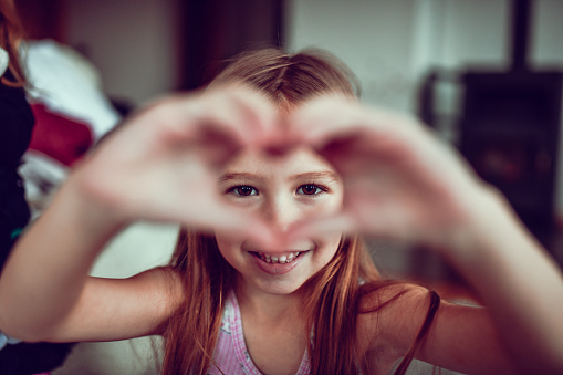 Smiling Female Child Making Heart Shape With Hands
