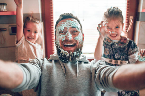 selfie door vader met schattige kind dochters na het koken en het maken van puinhoop met topping - keuken fotos stockfoto's en -beelden