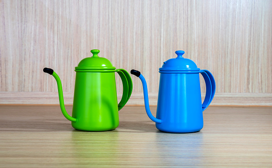 Green and blue coffee teapot  on woodden  background.Coffee maker concept.