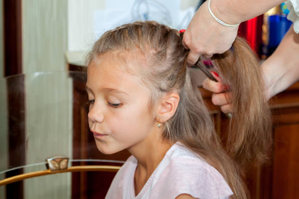 istock Mother combs her daughters hair and braids it at home 1302802389