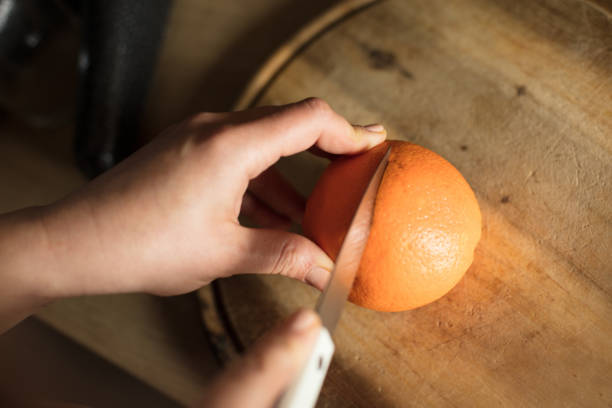 istock Woman in the kitchen cutting orange. 1302805662