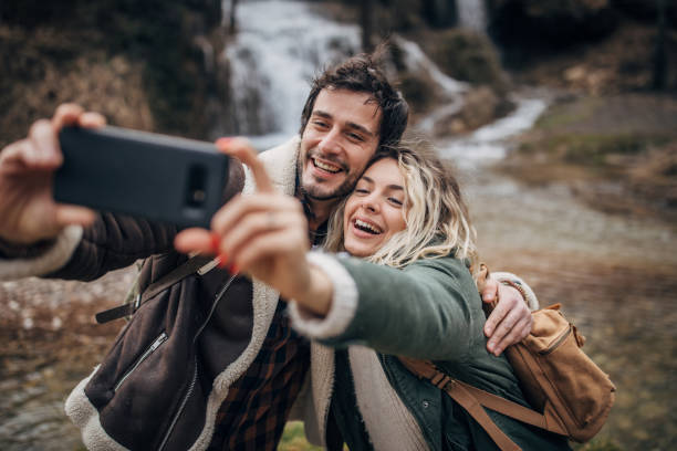 istock Happy couple taking a selfie by the waterfall 1302806432