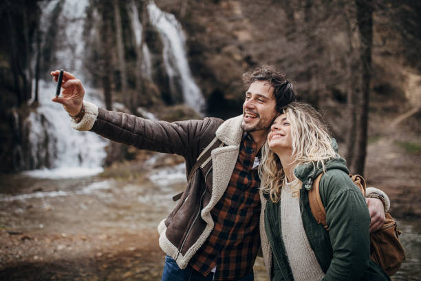 istock Happy couple taking a selfie by the waterfall 1302806474