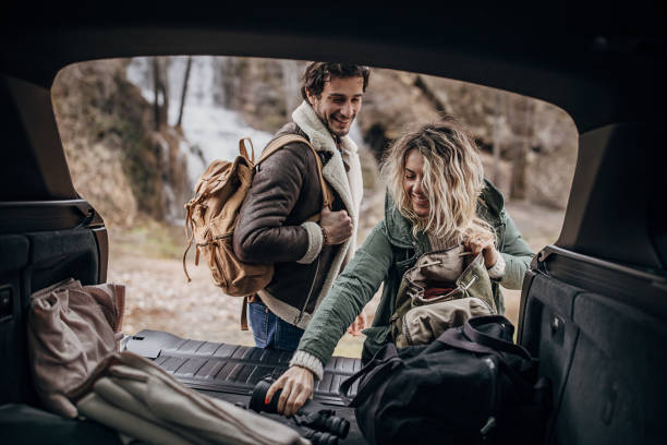 istock Couple taking hiking equipment from car trunk 1302807251