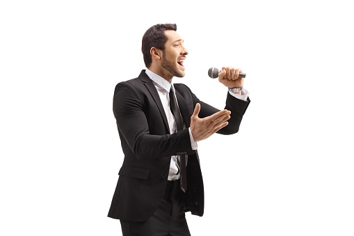 Man in a suit singing on a microphone isolated on white background