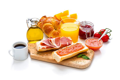 Spanish tomato and ham toast, croissant, coffee, orange juice and olive oil. Traditional Mediterranean breakfast or lunch on white background. High resolution 42Mp studio digital capture taken with Sony A7rII and Sony FE 90mm f2.8 macro G OSS lens