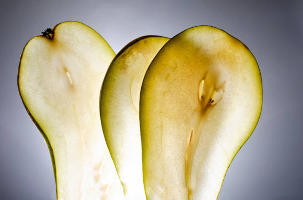 Slices of fresh juicy pear against grey background