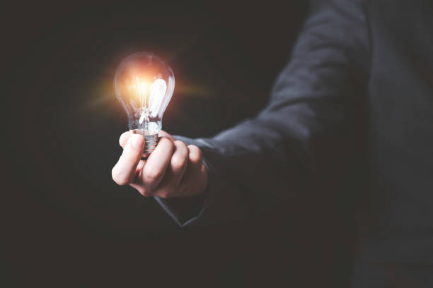 istock Businessman holding glowing lightbulb and using computer laptop to input business strategy idea , creative thinking ideas and innovation concept. 1302810490
