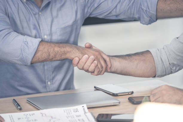 istock Business man shaking hands on office desk 1302810818