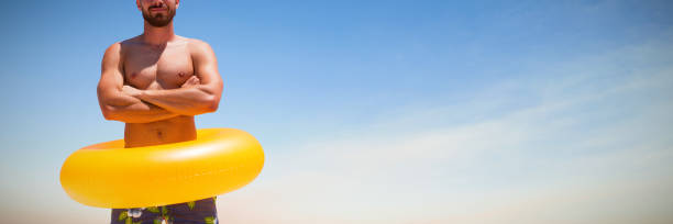 istock Composite image of young man with inflatable ring standing against white background 1302813282