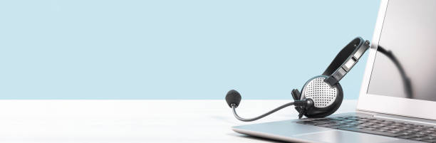istock Slim Laptop with headphones on white desk 1302813656