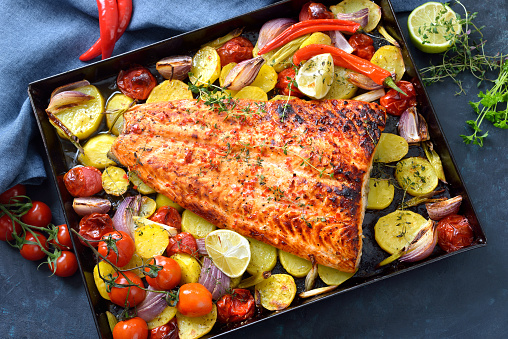 Large juicy salmon fillet with a chili honey marinade, baked with vegetables and served hot from the oven on a baking sheet