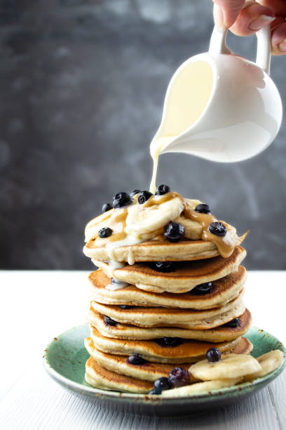 istock Condensed milk is poured onto a stack of pancakes 1302813942