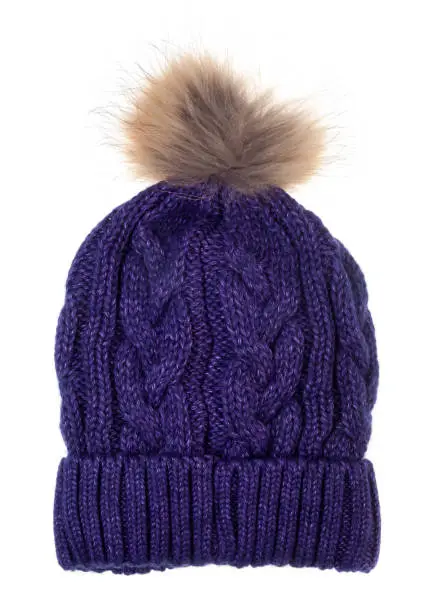 Purple woolly winter bobble hat decorated with cable knitting ornament isolated on white background. Handmade woolly cap with fur pompom on top