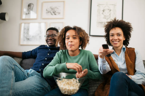 vista trasera de una familia afroamericana feliz viendo la televisión juntos - apartment television family couple fotografías e imágenes de stock