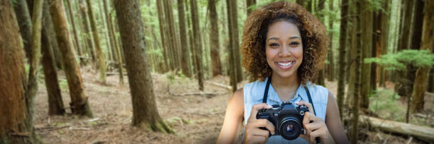 istock Composite image of smiling woman holding a camera 1302815236