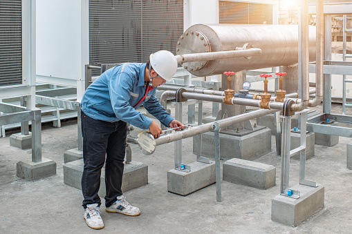 Industrial engineer inspection checking measure position of piping and valve before connecting or welding fixed of cooling water system in the factory