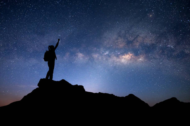 many stars , milky way and silhouette of man standing a lone on top of mountain and show two hands isolated on white background.concept to create energy and positive thinking. - milky way galaxy space star imagens e fotografias de stock