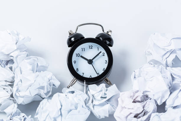 istock Alarm clock with crumpled paper balls.Timing and thinking idea concept. 1302816720