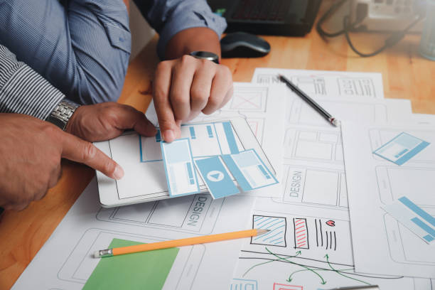 istock UX or UI designers designing on their smartphone application layout prototype project. 1302818119