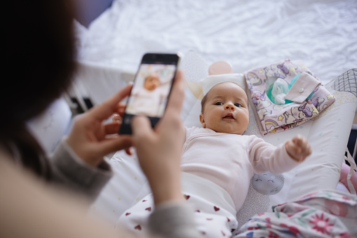 Mother taking photos of her daughter with phone