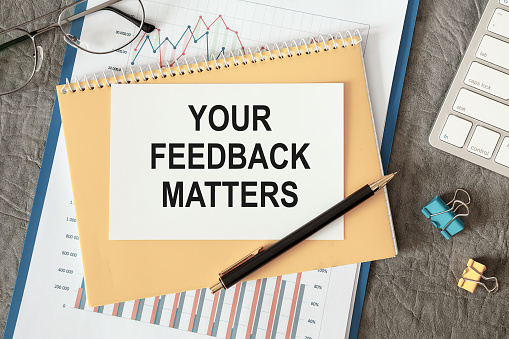 YOUR FEEDBACK MATTERS is written in a document on the office desk with office accessories.