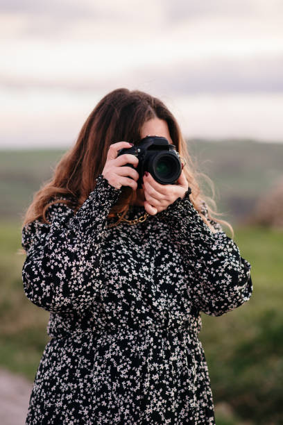 istock Young woman taking a picture with a DSLR camera 1302824792