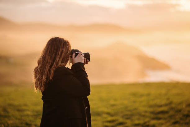istock Young woman taking a picture with a DSLR camera 1302825376