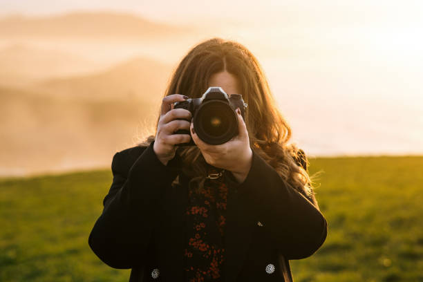 istock Young woman taking a picture with a DSLR camera 1302825426