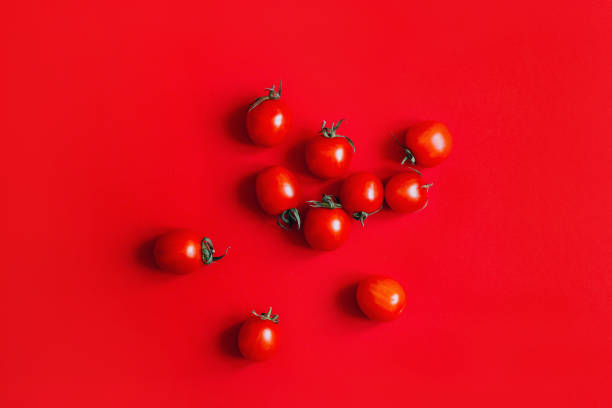istock top view of cherry tomatoes on red background 1302825470