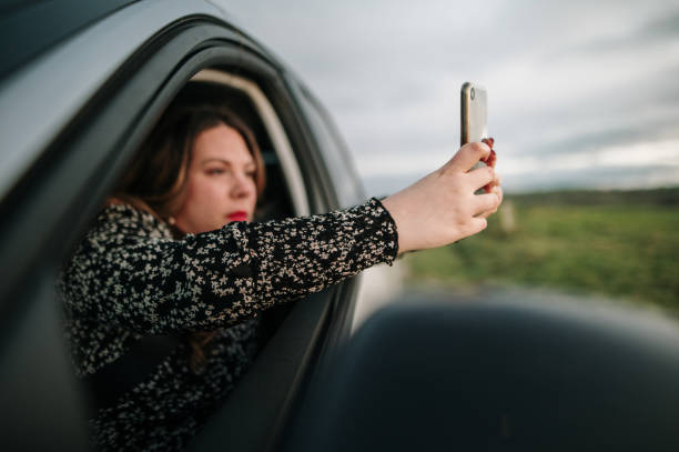 istock Young woman taking a picture from a car 1302825510