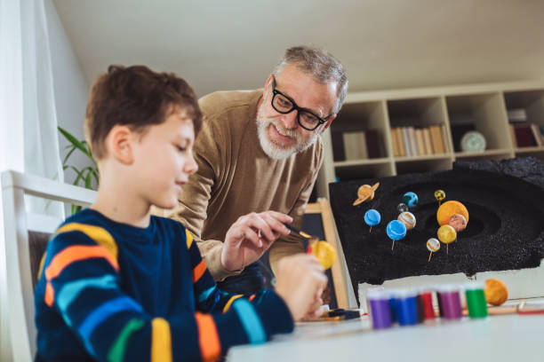 istock Happy school boy and his father making a solar system 1302827244