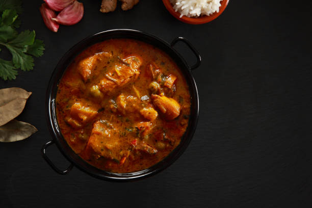 Chicken Curry Indian Cuisine of Chicken Curry on slate black platter garlic bulb photos stock pictures, royalty-free photos & images