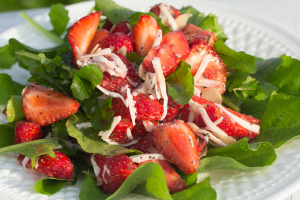 白いプレートと明るい背景にイチゴと夏のサラダ。クローズアップ - chandler strawberry ストックフォトと画像