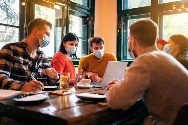 istock Diverse people with protective face masks having a business meeting in a restaurant 1302828404