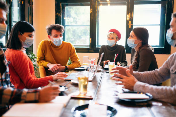 istock Group of diverse people on a meeting sharing ideas about a new project and wearing protective face masks 1302828435