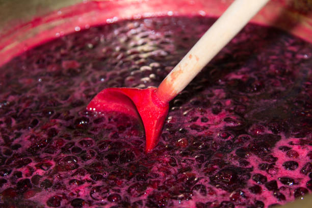 istock Blackcurrant jam boils in a copper basin and is stirred with a wooden spoon 1302828512