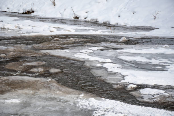 istock Frozen river in winter, snow and ice melting 1302829576