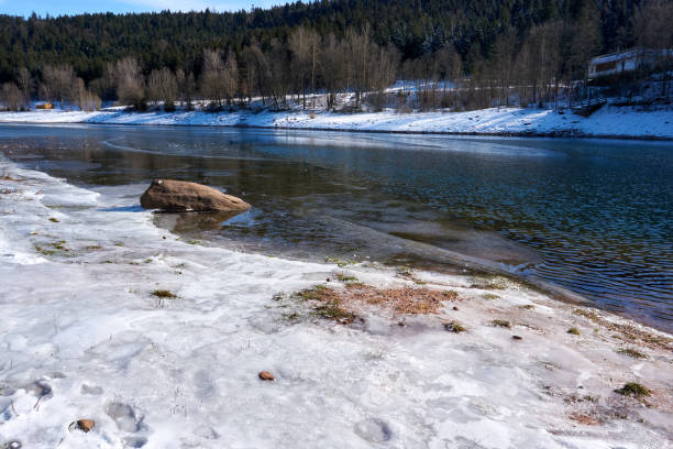 istock partially frozen river with snow and ice under a blue sky 1302830664
