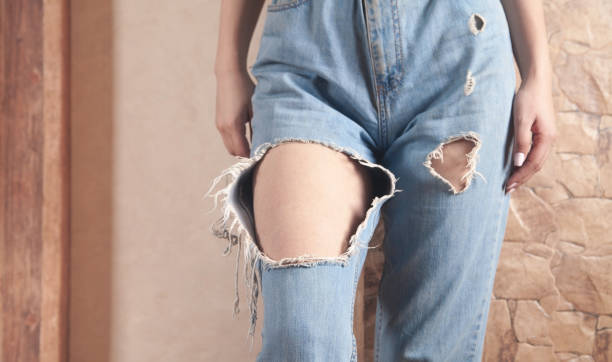 istock Young woman in modern torn jeans at home. 1302830861