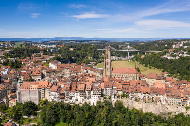aerial view of the fribourg old town with its cathedral and the modern poya bridge in switzerland. - fribourg imagens e fotografias de stock