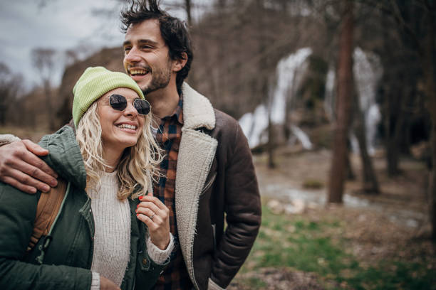 Man and woman, beautiful young couple hiking together in nature on a winter day.