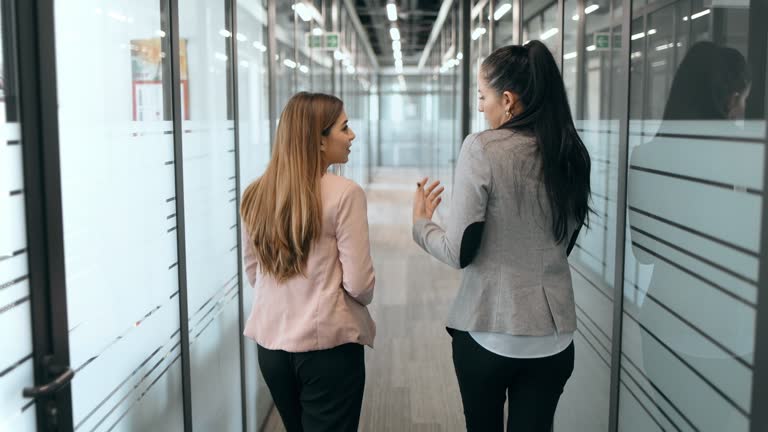 Businesswomen talking in office corridors