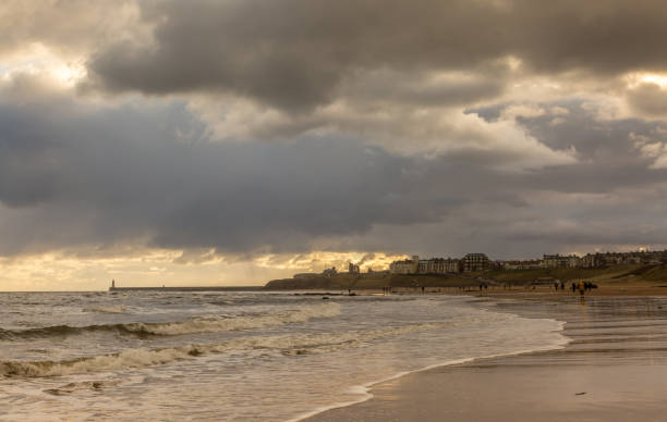 istock People taking a walk on Tynemouth's Longsands beach during Lockdown on a cloudy and rainy day, in the north east of England 1302842084