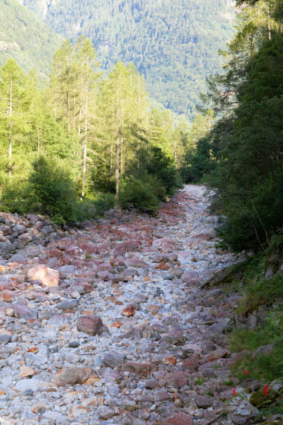 suiza, valle de verzasca: lecho seco con muchas piedras rojas lavadas, en algunos veranos hace mucho calor en el valle, los lugareños y turistas sufren de la larga sequía - riverbed switzerland valley stone fotografías e imágenes de stock