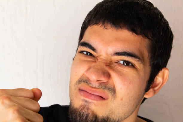 istock Young short-haired Hispanic man with black clothes, angry, furious, upset, stressed posing on a white background 1302842350
