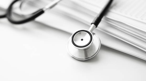 istock Stack of report medical documents and stethoscope isolated on white background 1302842392